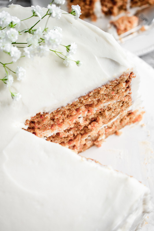 Close up shot of peach carrot cake with a slice taken out of it