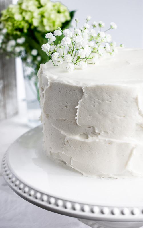 Carrot layer cake on a white cake stand