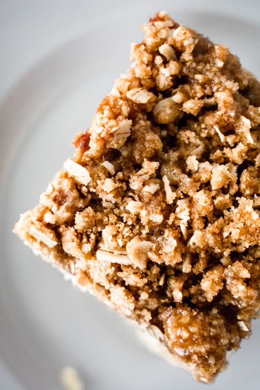 Cinnamon crumble on top of an apple pie bar