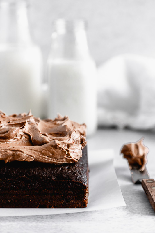 Side view of dark chocolate snack cake with dark chocolate buttercream on top