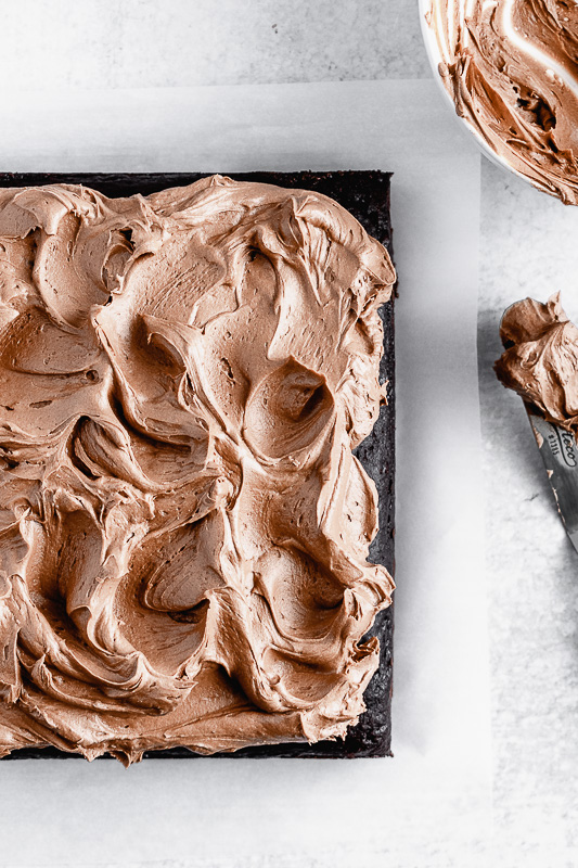 Top view of an 8 inch dark chocolate snack cake covered in dark chocolate buttercream
