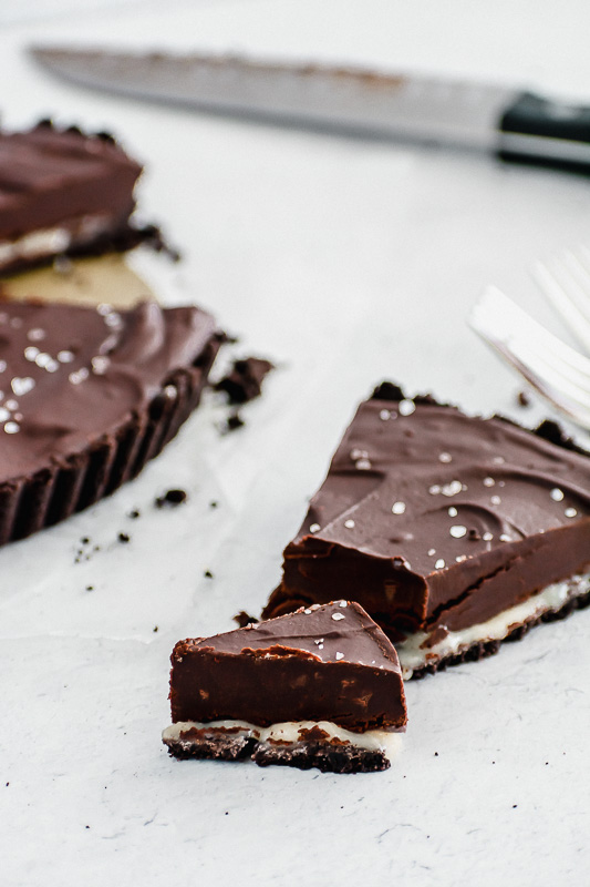 Slice of salted dark chocolate tart with homemade caramel sauce in the middle