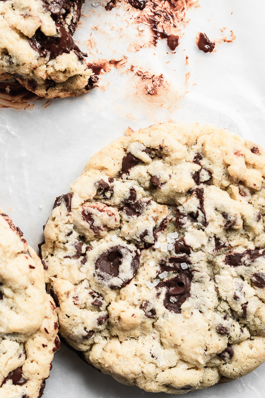Close up of big chocolate chip cookies on white parchment paper