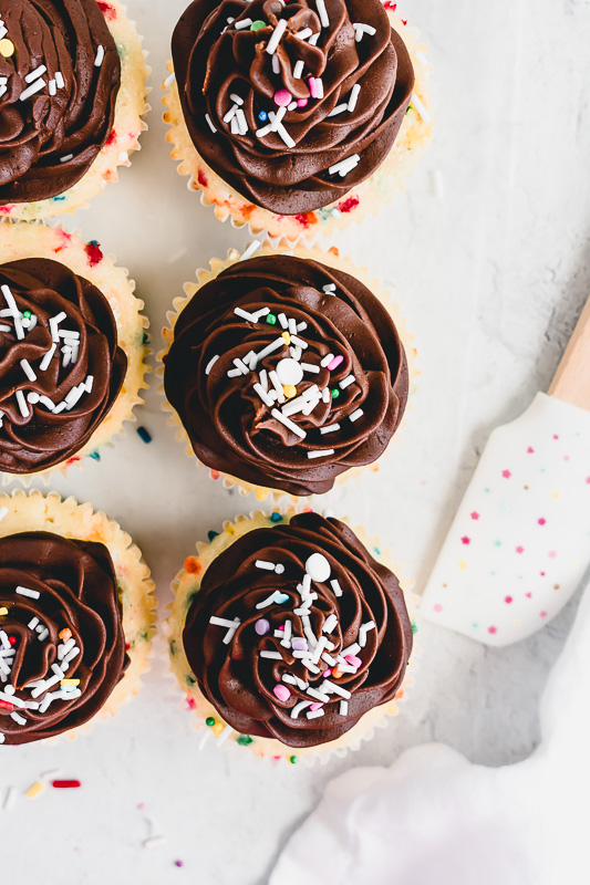 Tops of funfetti cupcakes with chocolate fudge buttercream