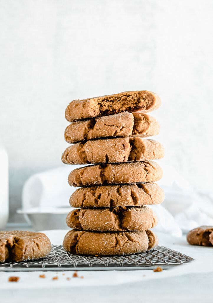 Ginger molasses cookies stacked on top of each other on a wire rack