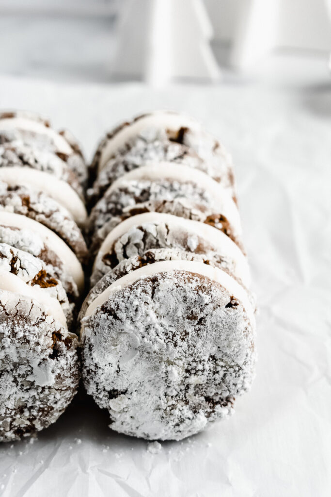 Powdered sugar on gingerbread crinkle cookie sandwiches 
