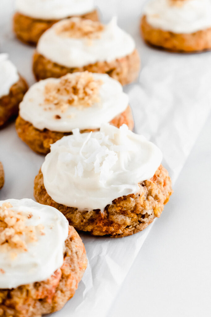 Carrot cake cookies with cream cheese frosting on parchment paper