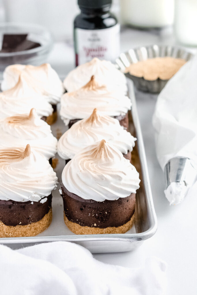Mini s'mores chocolate cheesecakes on a metal baking tray
