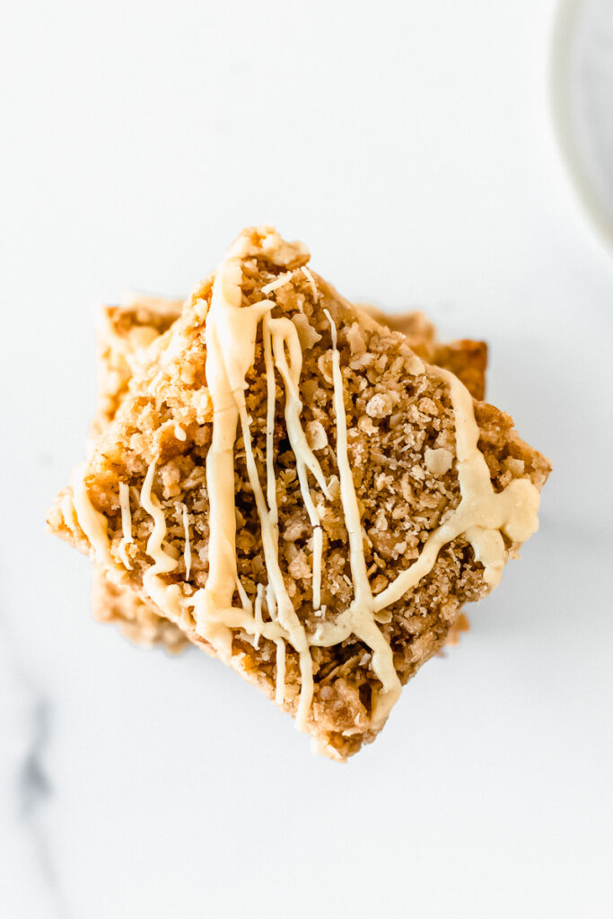 A stack of easy apple pie bars covered in vanilla maple glaze