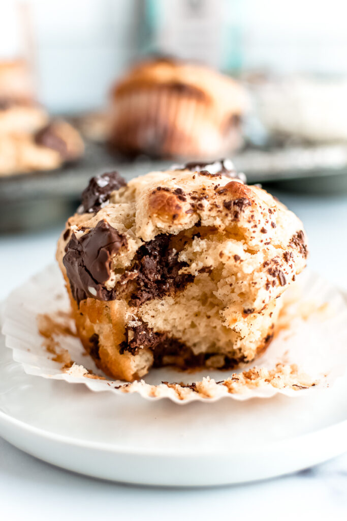 Coconut almond chocolate chunk muffin unwrapped on a white plate